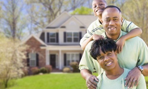 Happy African American Family In Front of Beautiful House.